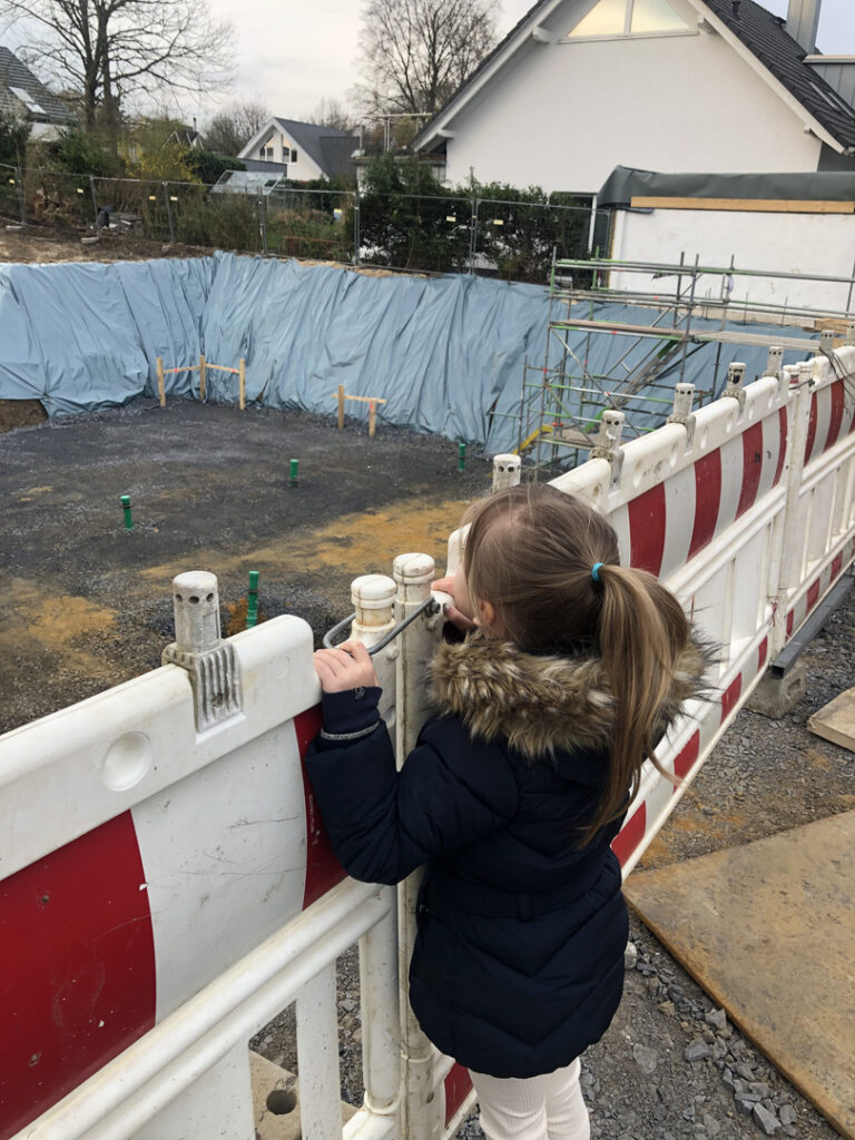 Mädchen schaut in eine Baugrube